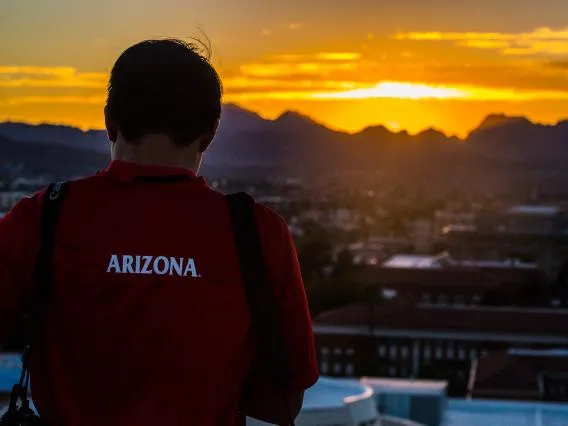 Photo of a student taking a photo of a sunset